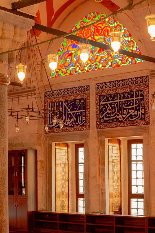 Free Beautifully decorated mosque interior with stained glass and calligraphy art. Stock Photo
