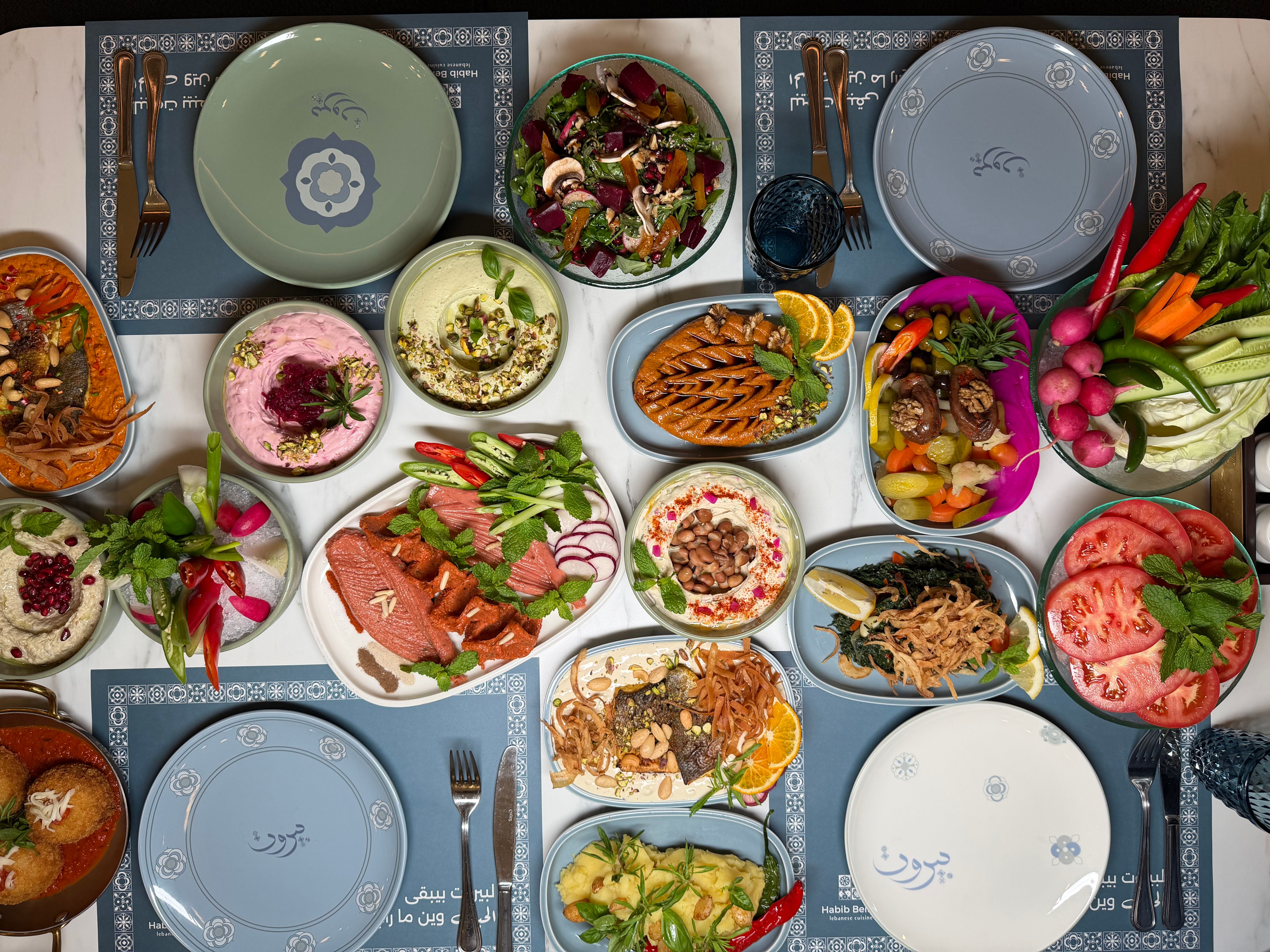Ücretsiz Humus, salata ve ızgara sebzeler de dahil olmak üzere Orta Doğu yemeklerinden oluşan renkli bir sofra, şenlikli bir buluşma için mükemmel. Stok Fotoğraflar