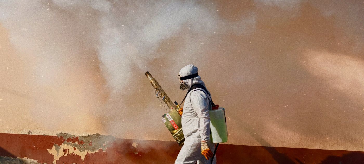 A pest control technician in protective equipment treating a property in Malaysia