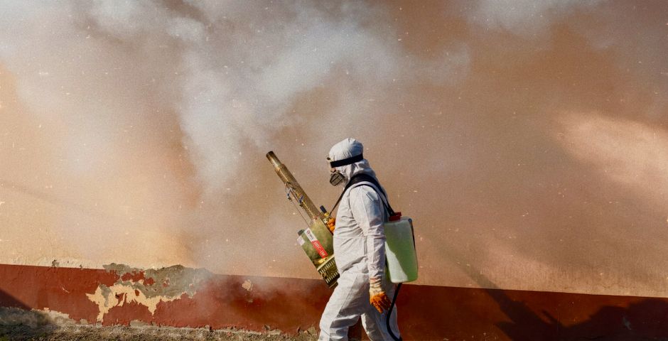 A technician treating a property in protective gear — the right product in the right place matters more than the dose
