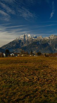Captivating view of snow-capped mountains and agricultural fields under a clear sky.
