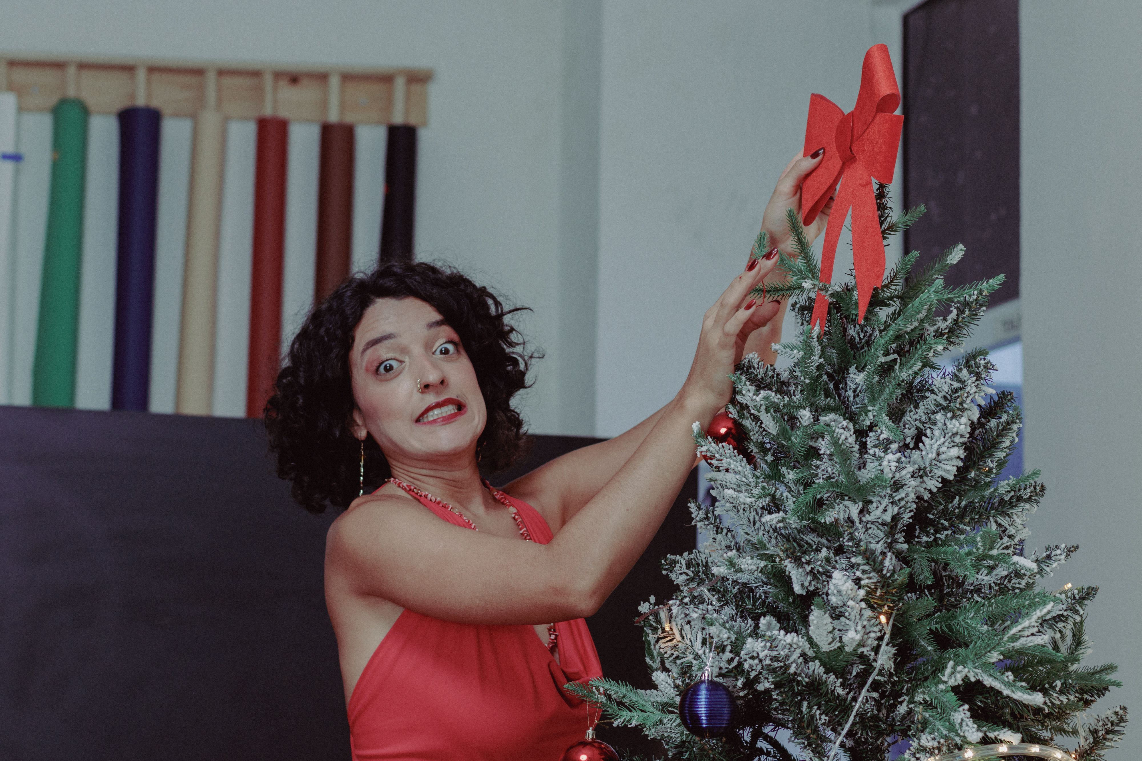 Femme Décorant Un Sapin De Noël Avec Un Nœud Rouge · Photo gratuite