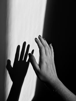 一张单色照片巧妙地捕捉到一只手在墙上投射的阴影