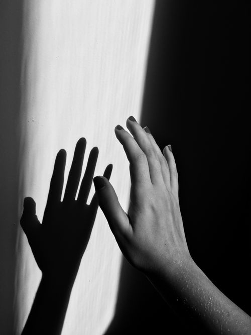 Free A monochrome photo of a hand casting a shadow on a wall, artfully captured. Stock Photo