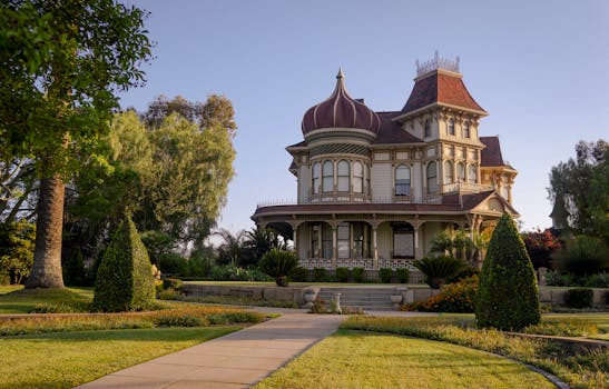 Elegant Victorian house in Redlands, showcasing 19th-century architecture surrounded by lush gardens.