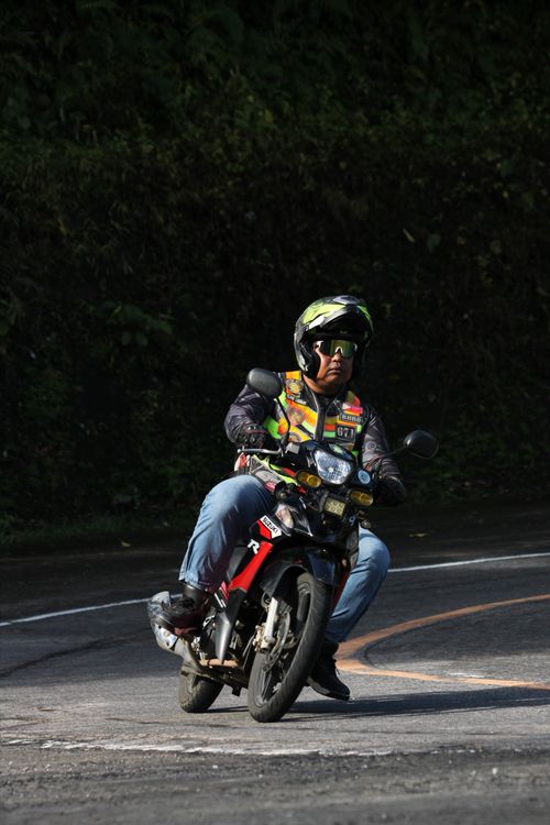 Free A motorcyclist in gear navigates a sharp curve on an open road, showcasing skill and control. Stock Photo