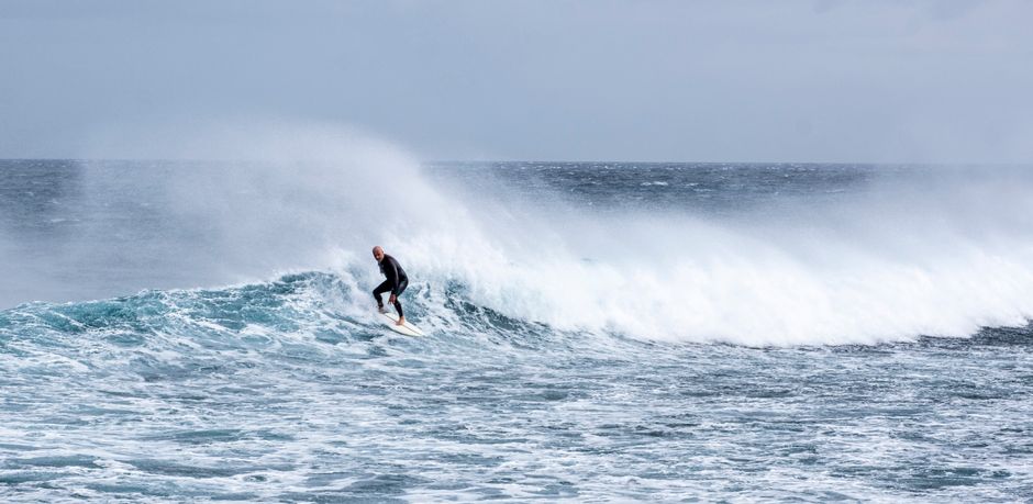 Thrilling image of a surfer riding powerful ocean waves, showcasing adventure and skill.