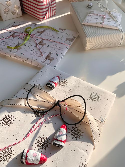 Free Beautifully wrapped Christmas gifts with decorative bows and sunlight casting shadows. Stock Photo