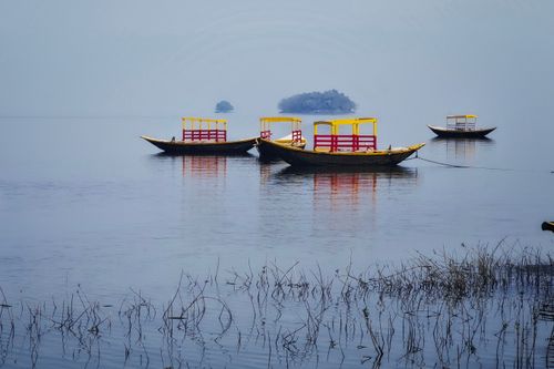 Free Colorful traditional boats float on tranquil waters near Maithon, India. Stock Photo