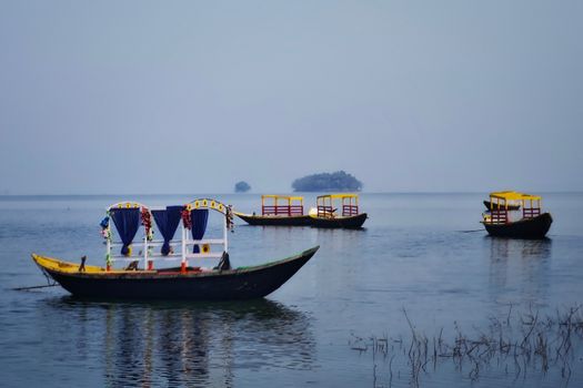 Colorful boats on serene Maithon Lake, Jharkhand, ideal for travel and leisure activities.
