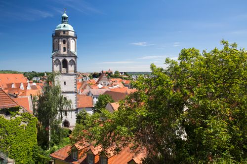 Free Charming aerial view of a historic town with red-tiled roofs and a prominent church tower. Stock Photo