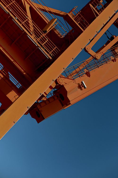 Free Close-up view of an industrial crane's structure set against a clear blue sky. Stock Photo