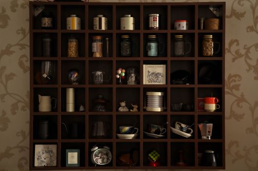 A neatly arranged shelf displaying various kitchenware and decor items in a cozy setting.