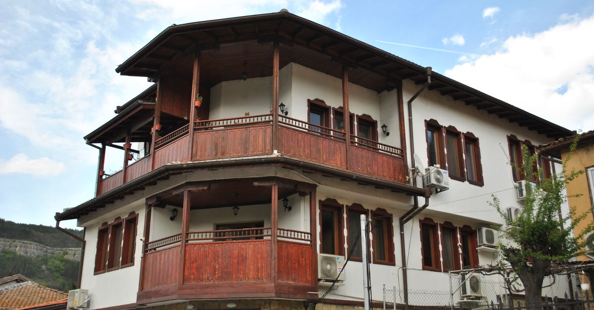 Beautiful two-story Eastern European house with wooden balconies and traditional design.