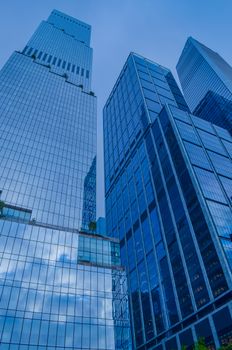 Capture of high-rise glass towers reflecting the sky in Midtown Manhattan, New York City.