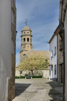 Charming view of a historic church and cobblestone street in Baeza, Andalucía, Spain.