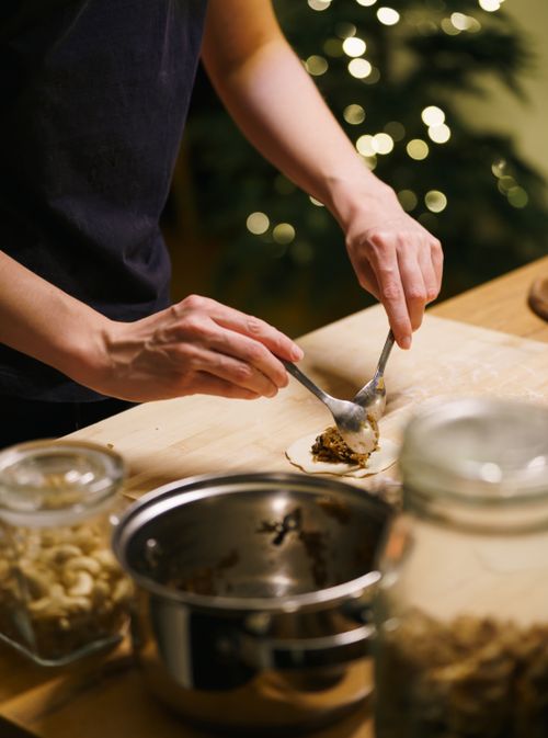 Free A person prepares handmade pierogies in a festive kitchen, embodying warmth and tradition. Stock Photo