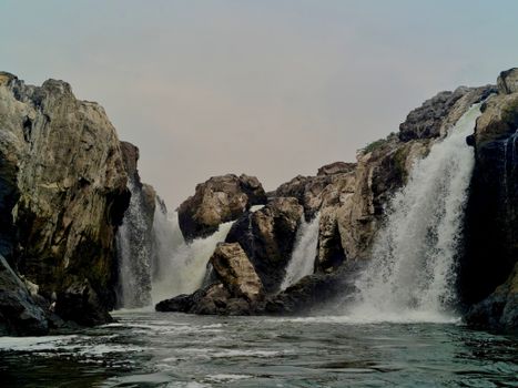 Explore the majestic beauty of Hogenakkal Waterfalls cascading over rugged rocks in Tamil Nadu, India.