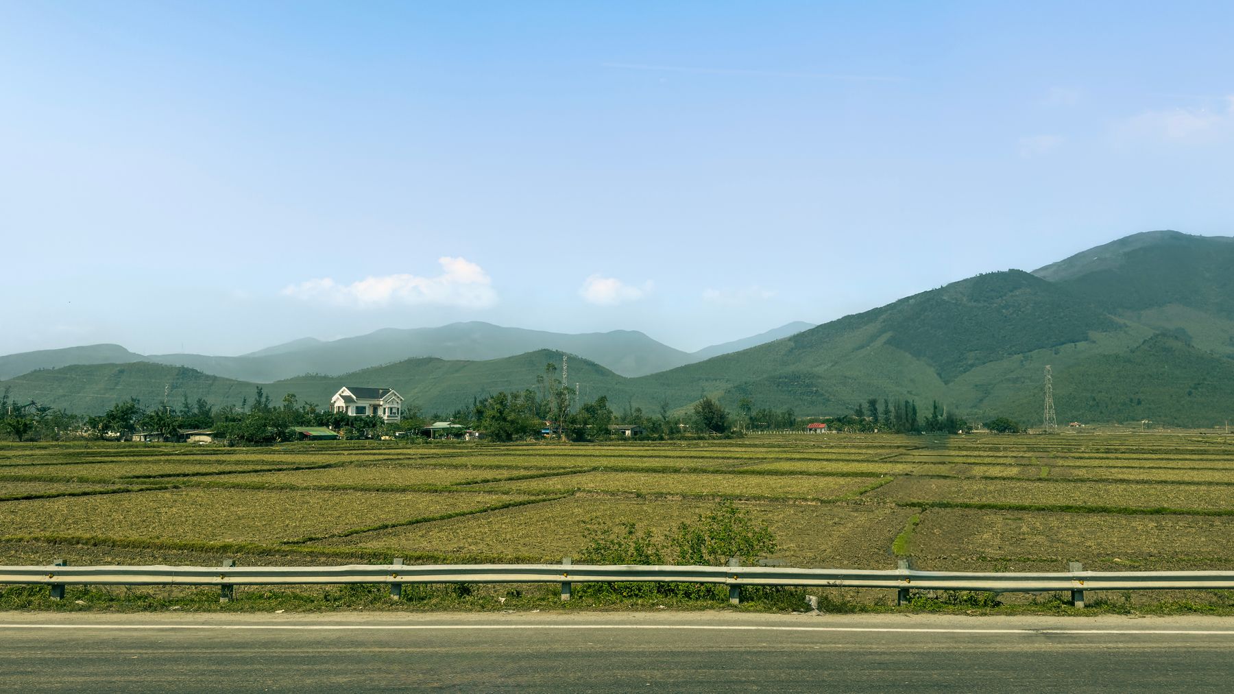 Khung cảnh nông thôn Việt Nam tuyệt đẹp với những thửa ruộng và núi non dưới bầu trời xanh trong.