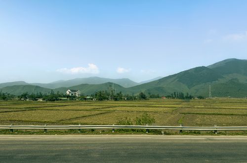 Free Beautiful view of Vietnamese countryside with rice fields and mountains under a clear blue sky. Stock Photo