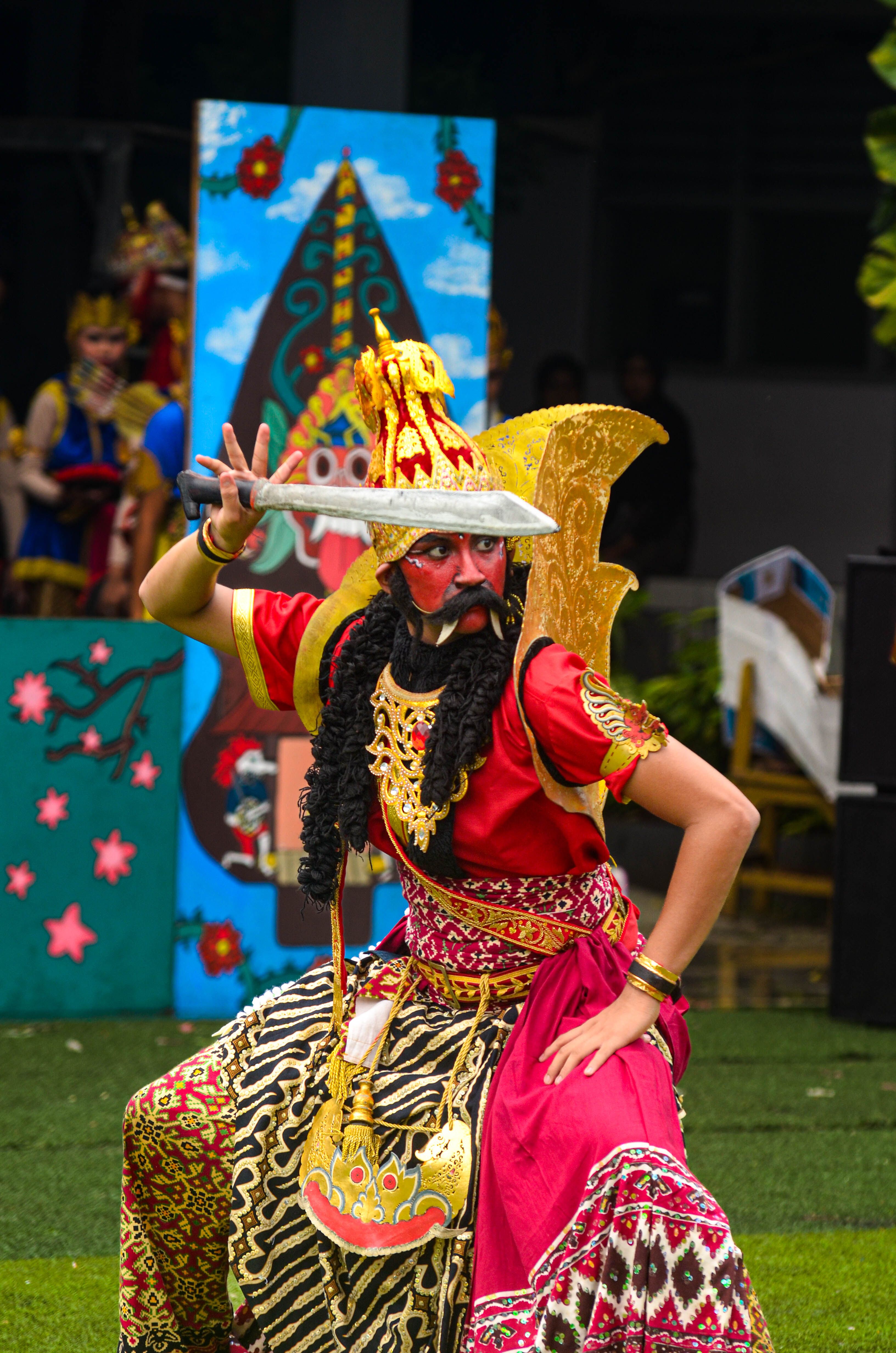 Vibrant Javanese dancer in traditional attire performing a cultural dance at an outdoor event.