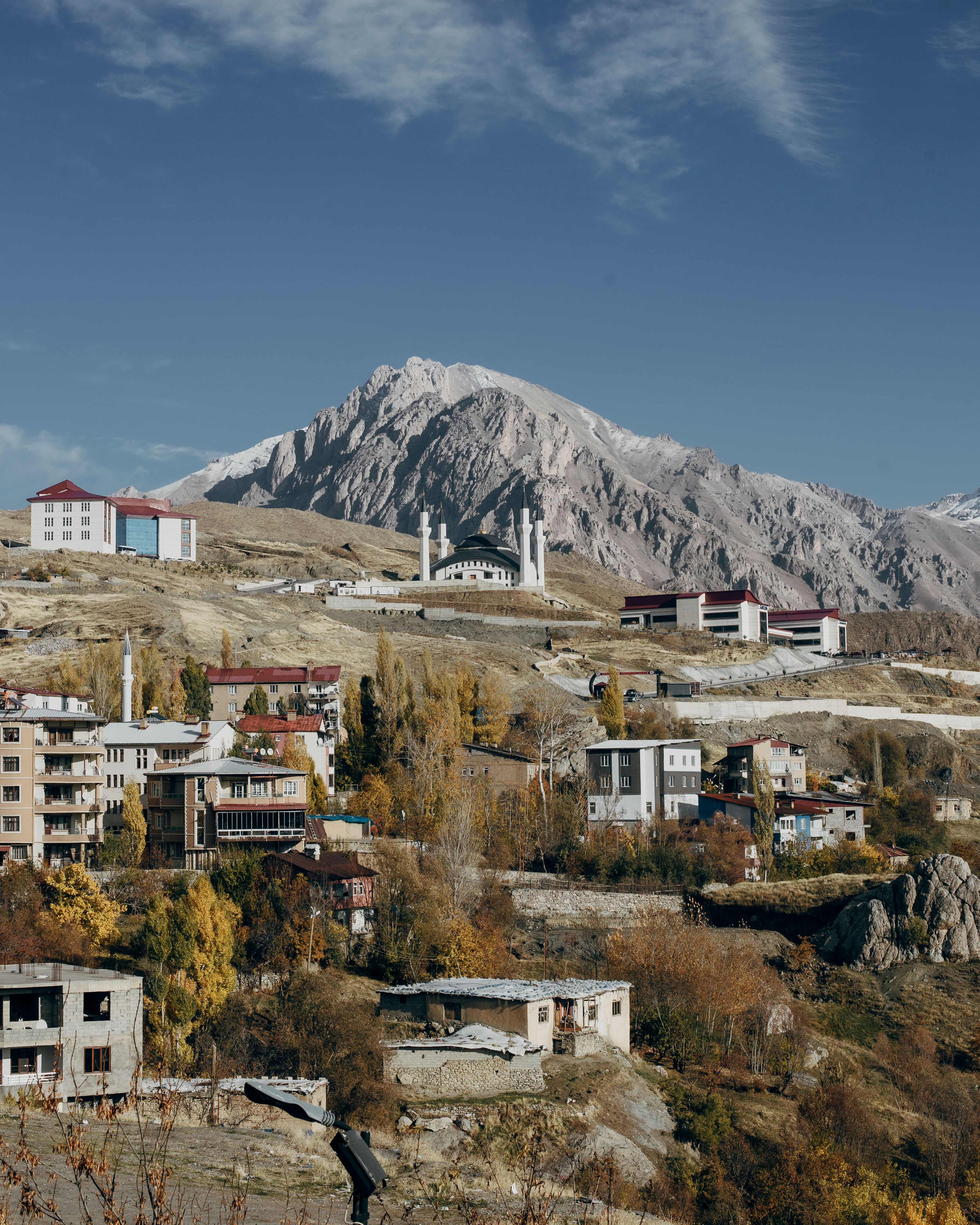 Picturesque autumn landscape showcasing Hakkâri with mountain backdrop and vibrant foliage.