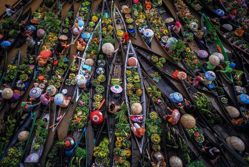 Free Aerial view of a bustling floating market in Kalimantan, Indonesia, filled with vendors and colorful produce. Stock Photo