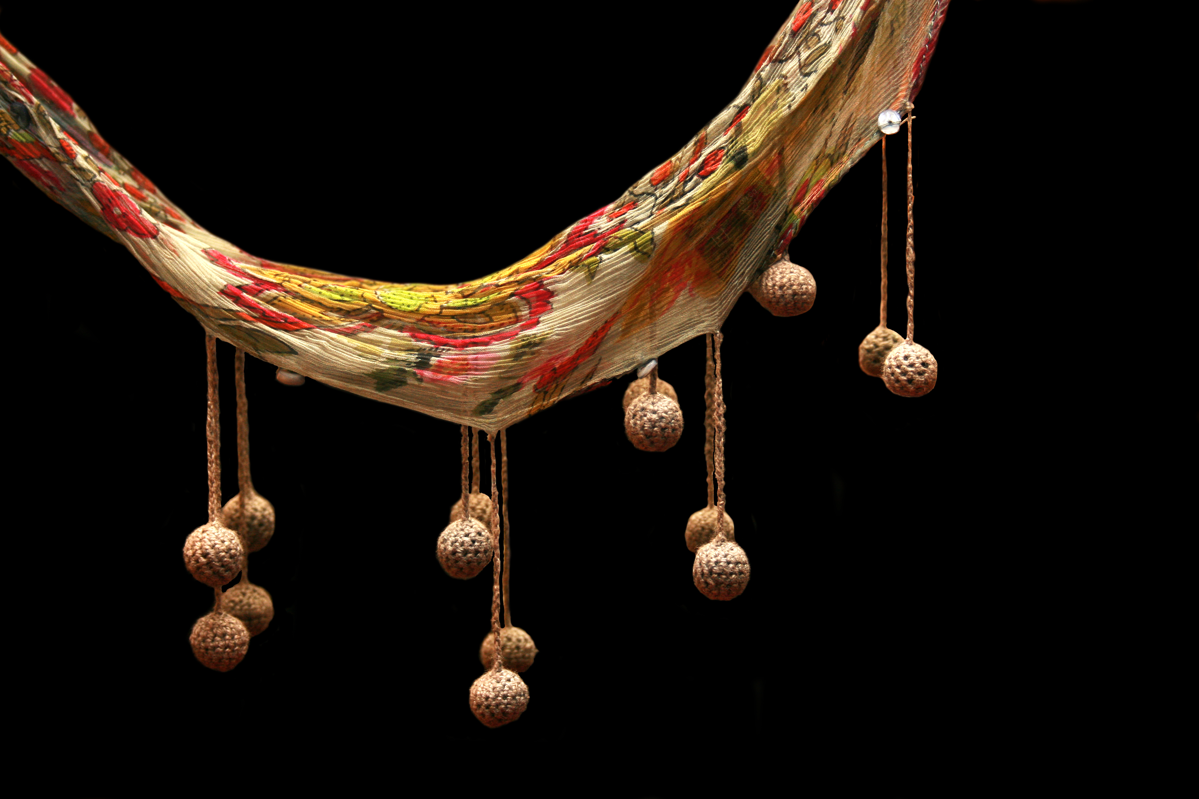 Beautifully crafted textile art with intricate patterns and hanging ornaments.