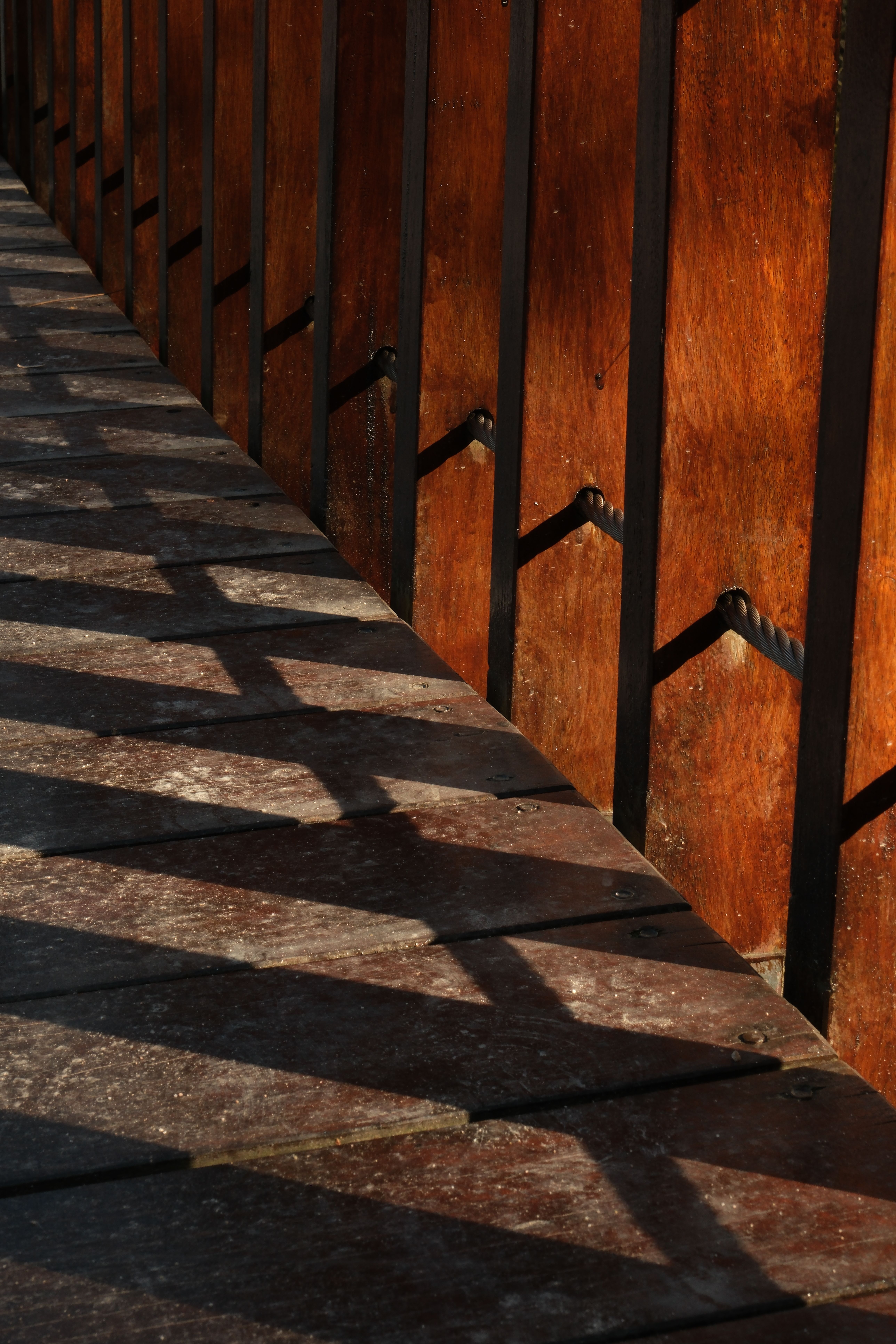 Dramatic shadows cast on a wooden deck in İstanbul, capturing artistic patterns.