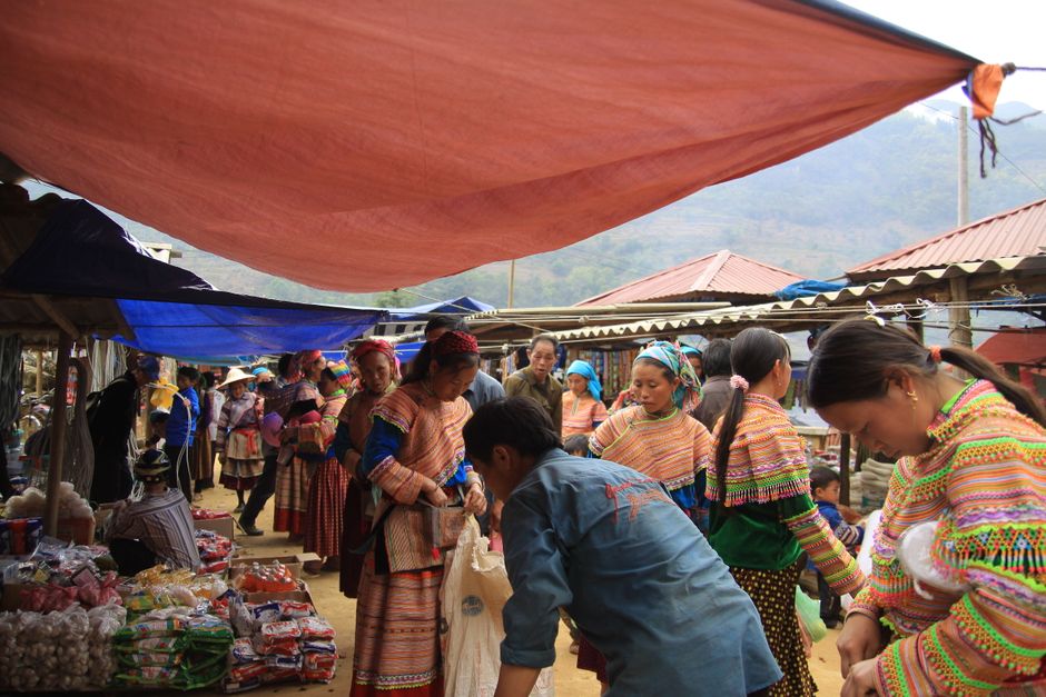 Diverse cultural landscape of Quang Ninh province, Vietnam, showing a collage-like realistic scene of mountains, terraced hills, coastal fishing communities, ethnic villages, and local markets, vibrant yet authentic, travel editorial photography, highly detailed
