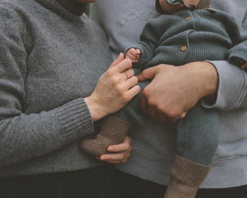 Free Close-up of parents gently holding their baby, showcasing family love. Stock Photo