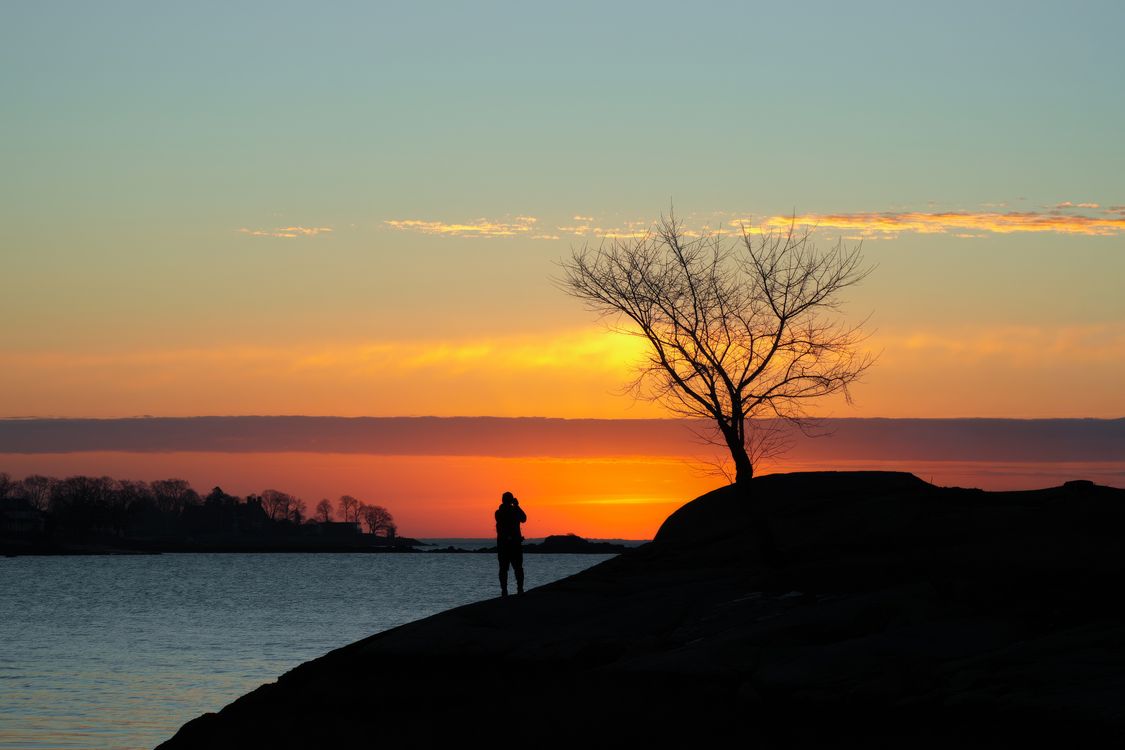 Silhouette of Photographer at Sunset by the Sea · Free Stock Photo