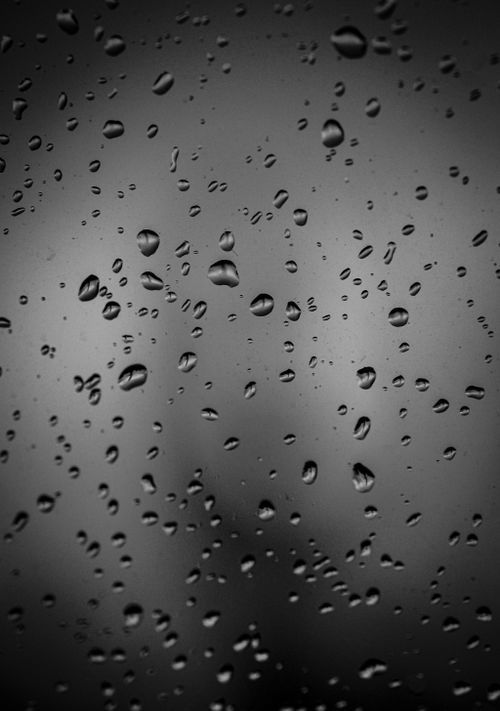 Free Close-up view of raindrops on a smooth glass surface creating a moody pattern. Stock Photo