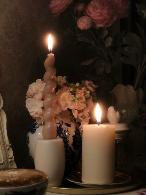 Free Warm candlelit scene with floral arrangement in vintage setting. Stock Photo
