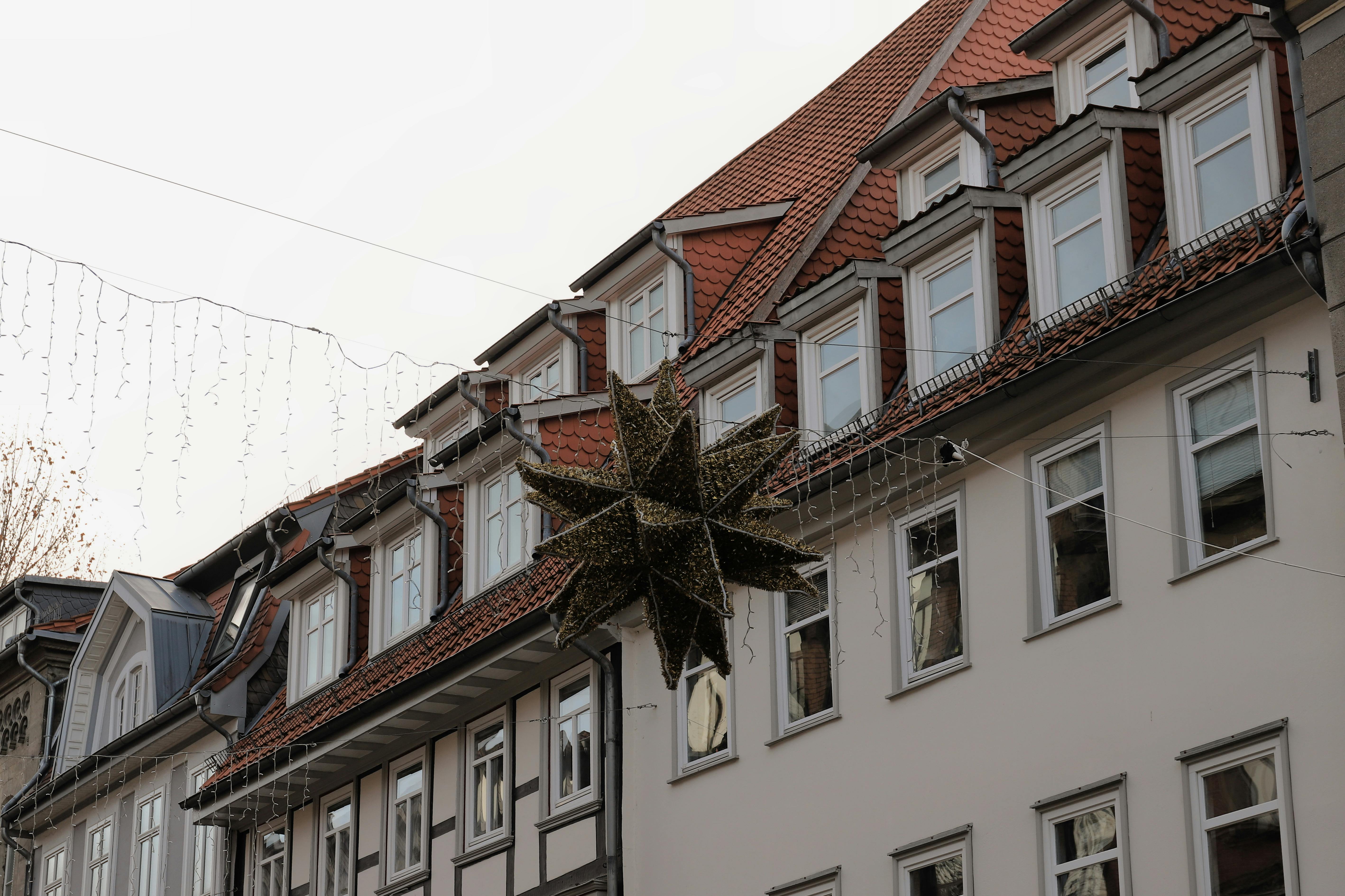 Beautiful Christmas decorations adorn classic German townhouses in Göttingen during winter time.