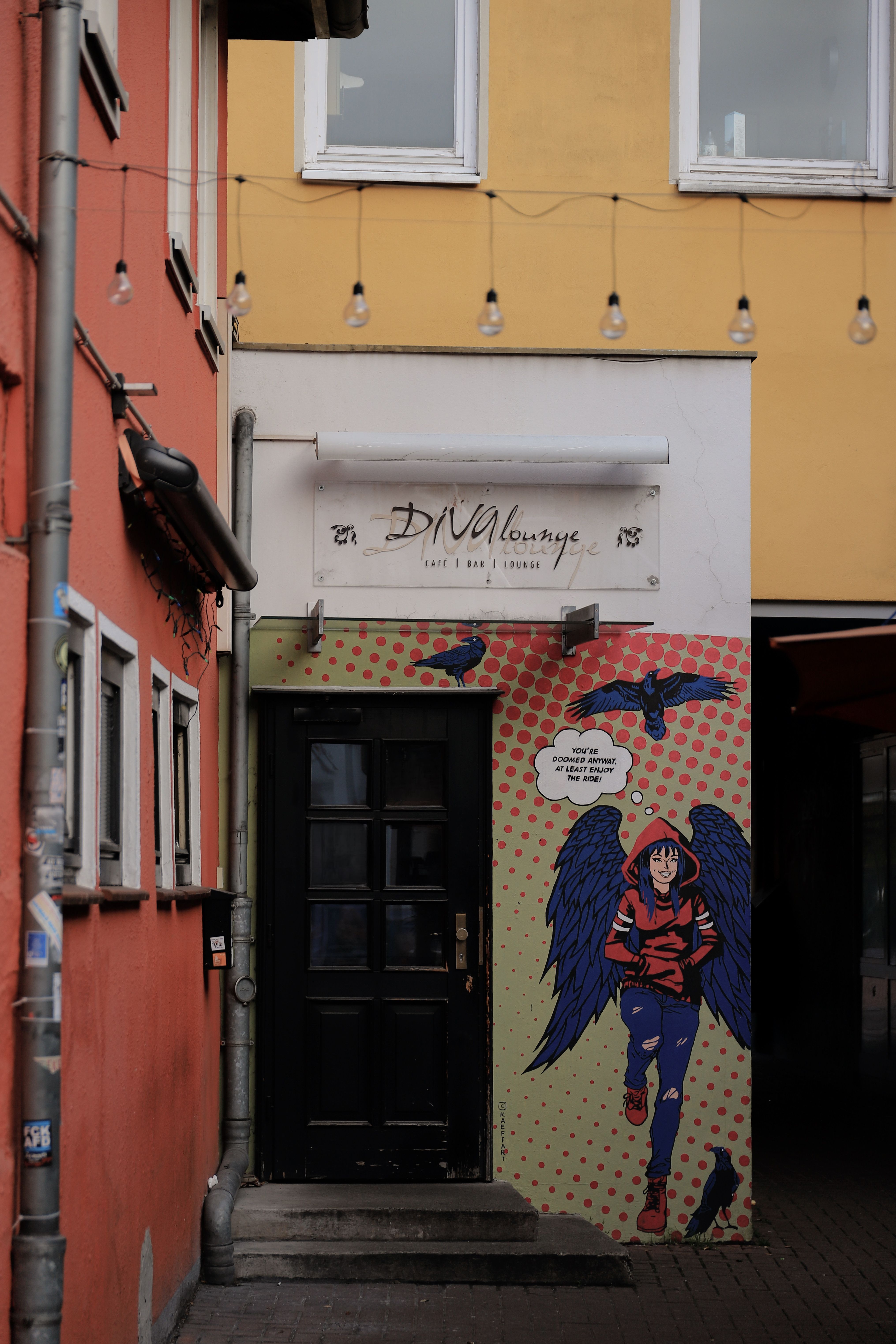 Vibrant street art on a building facade in a Göttingen alleyway, showcasing unique urban charm.