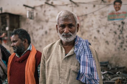 Free Candid portrait of an elderly man in Varanasi's bustling streets. Stock Photo