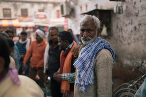 Free A bustling street scene in Varanasi featuring local people gathered together. Captures the essence of daily life. Stock Photo