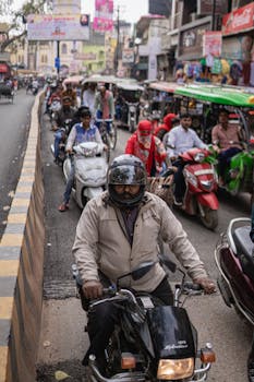 Diverse street scene with motorbikes and tuk-tuks in Varanasi's busy roads.