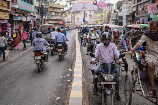 A lively street scene in Varanasi with motorcycles, rickshaws, and pedestrians.