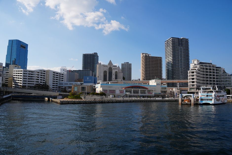 A clear daytime view of Kobe Port's skyline featuring modern architecture and waterfront.