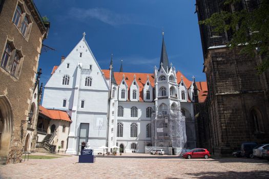 A picturesque European courtyard with historic buildings under a clear blue sky.