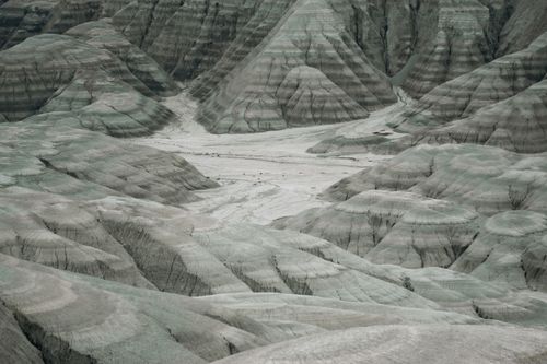 Free Aerial view of desolate badlands with unique geological formations and muted colors. Stock Photo