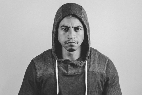 Free Black and white portrait of a man wearing a hoodie, expressing a moody and intense expression. Stock Photo