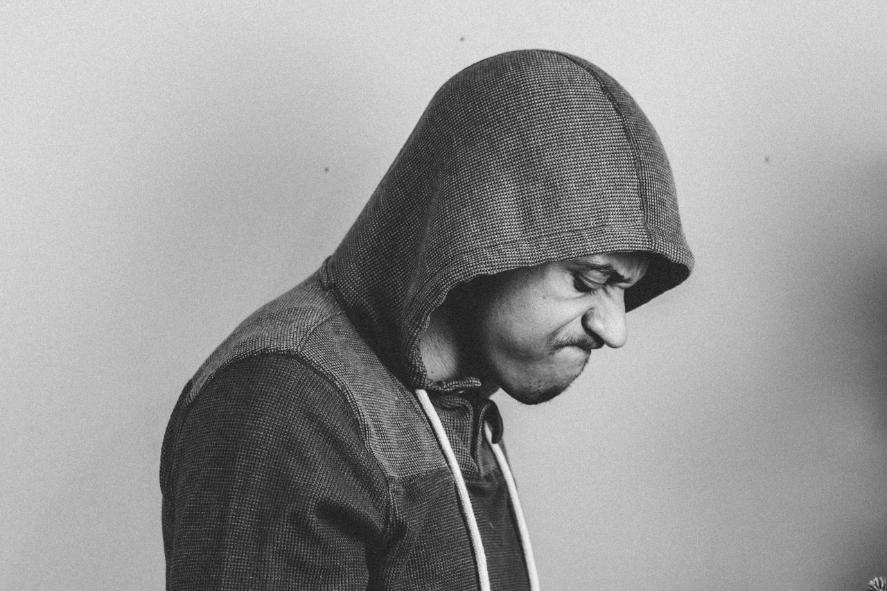black and white portrait of a man in a hoodie expressing frustration