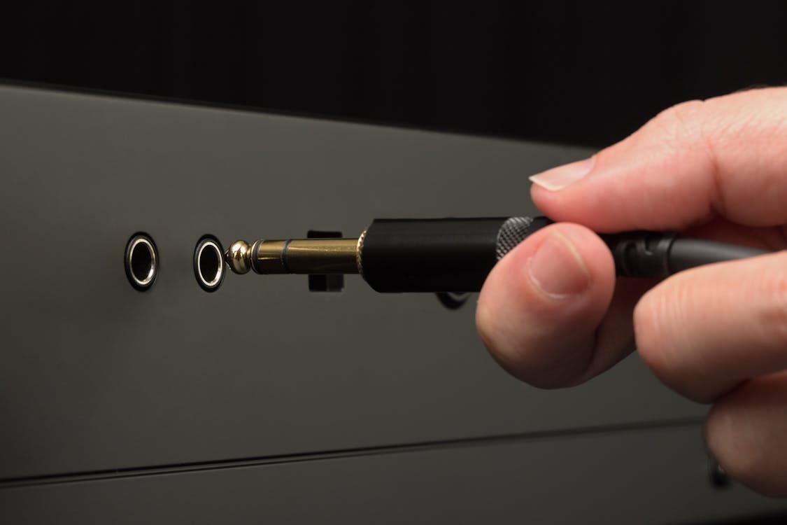 Person Plugging Audio Cable
