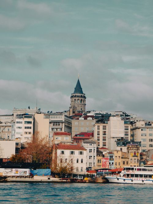 Free Beautiful view of the iconic Galata Tower surrounded by buildings in Istanbul, on a cloudy day. Stock Photo