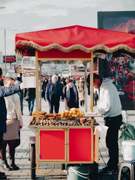 Street vendor selling roasted chestnuts on a bustling city street with a colorful cart.