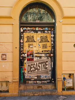 Old door decorated with urban art and graffiti in a city street setting.