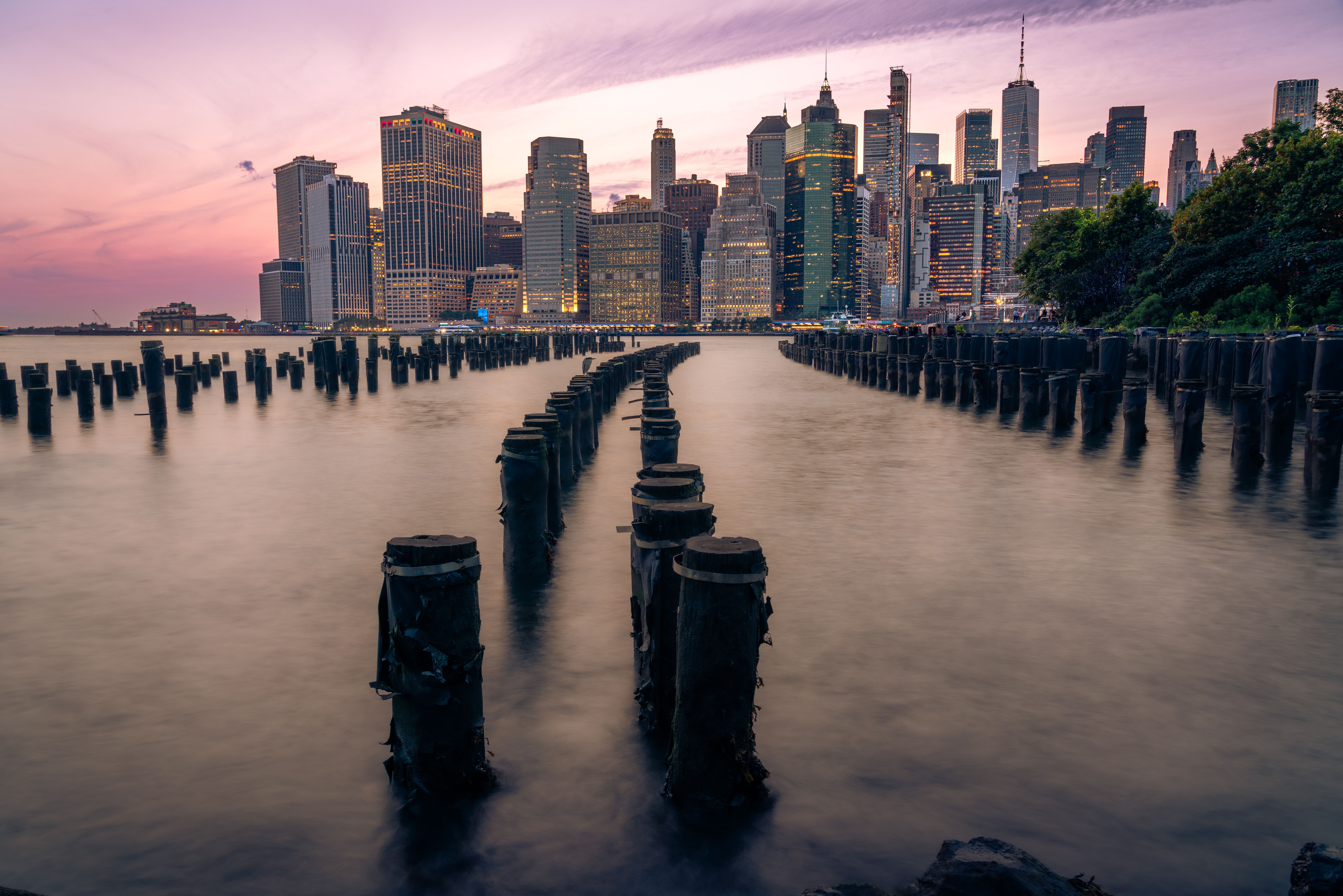 Stunning view of New York City skyline at sunset, captured from Brooklyn Bridge Park, showcasing iconic skyscrapers.